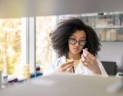 Eine junge Frau untersucht in einem Labor eine Probe.