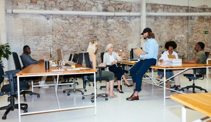 Gruppe von Kolleg*innen verschiedenen Alters besprechen Projekt im Büro